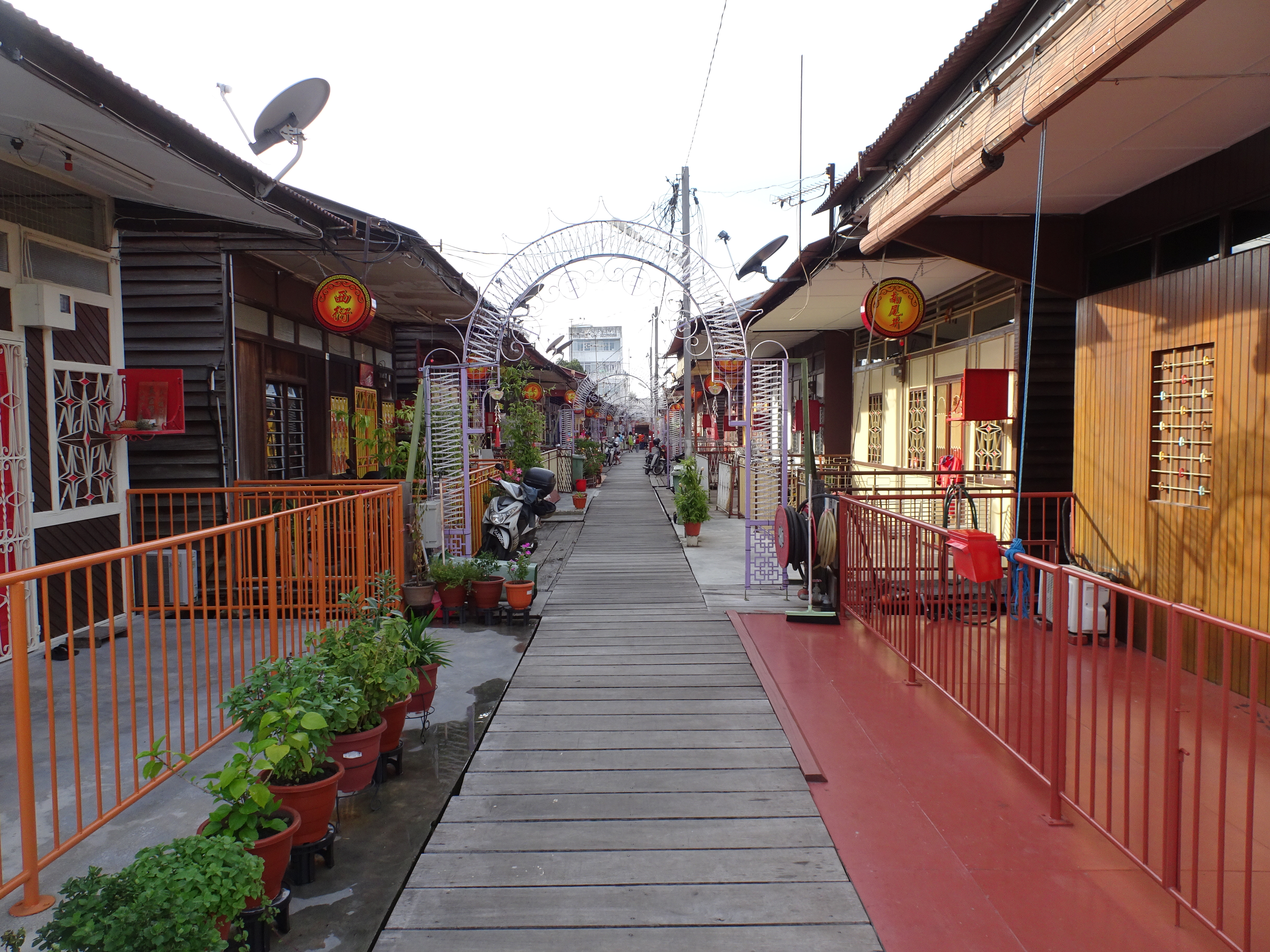 Perspective view of the Chew Jetty wooden boardwalk lined with stilt houses